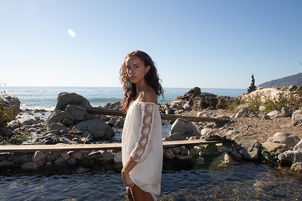woman standing sideways in an ocean creek